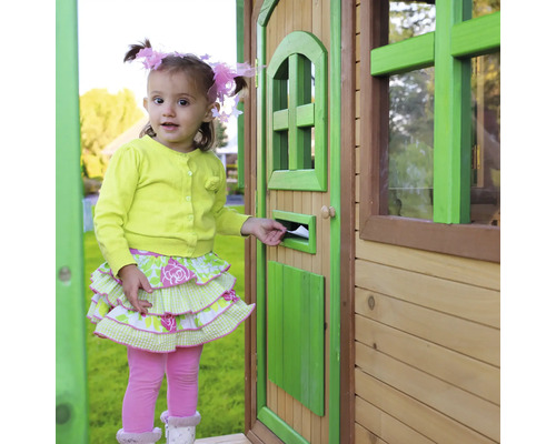 Mädchen steckt Brief in Briefkasten an einem Spielhaus