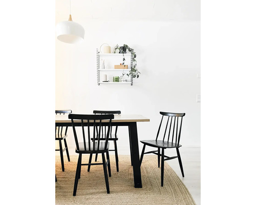 Esszimmer mit Holztisch, schwarzen Stühlen und Wandregal