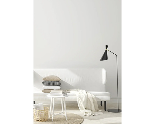 Helles Wohnzimmer mit Sofa, Tisch, Lampe und dekorativen Textilien