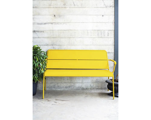 Gelbe Metallbank im Aussenbereich vor einer Betonwand