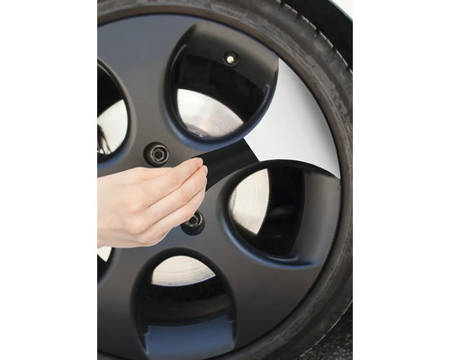 Detailaufnahme einer Person, die ein Klebeband an einer Felge anbringt.