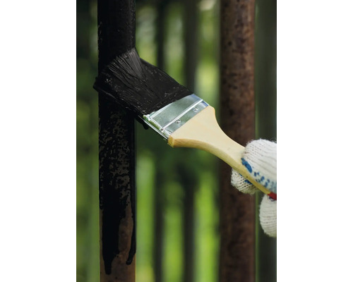 Anstreichen eines Metallzauns mit einem Pinsel