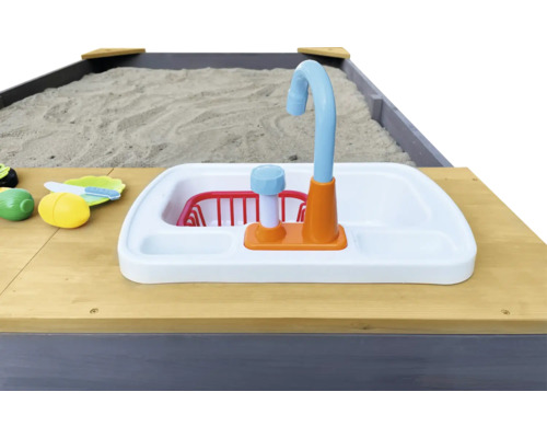 Detailansicht eines Sandkastens mit Spielküchenspüle und Spielzeug