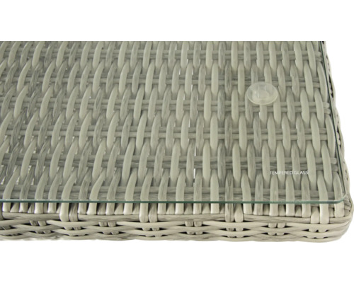 Detailansicht einer Tischplatte mit Glasplatte und Rattanstruktur