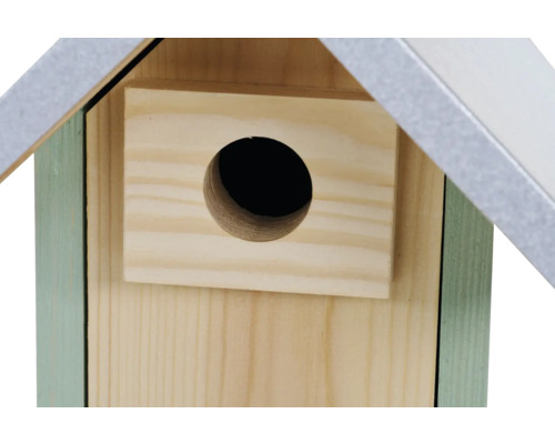 Detailansicht eines Nistkastens aus Holz mit einem runden Einflugloch