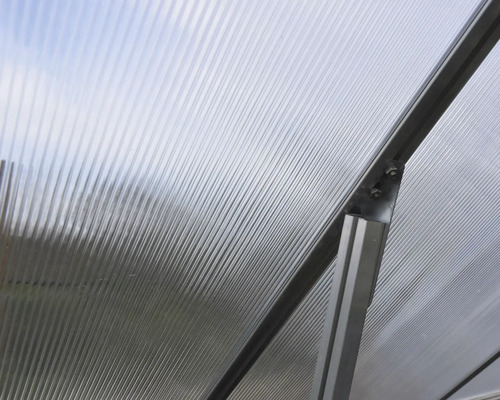 Detailansicht eines Gewächshauses mit Wellplatten und Aluminiumrahmen