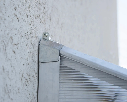 Detail einer montierten Haustürüberdachung an einer Hauswand