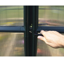 Hand öffnet eine Gewächshaustür mit Griff