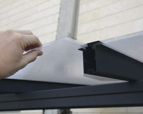 Installation einer transparenten Stegplatte in eine Halterung für Terrassenüberdachungen.