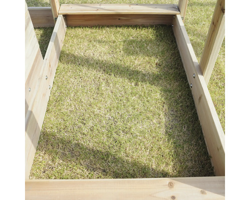 Detailansicht eines Hochbeets aus Holz überwachsen mit Gras.