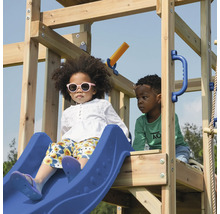 Kinder spielen auf einem Spielplatz mit Rutsche, Kletterwand und Schaukel