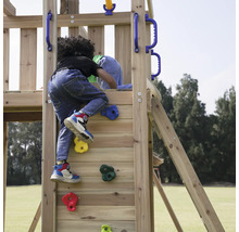 Kind klettert auf ein hölzernes Spielgerät mit Kletterwand