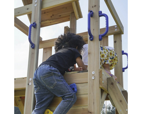 Kinder klettern auf einem hölzernen Spielturm mit blauen Griffen und Klettersteinen.