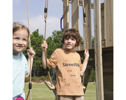 Kinder spielen auf einem Holzspielturm mit Schaukeln im Freien