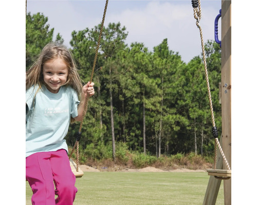 Mädchen schwingt auf einer Holzschaukel im Garten