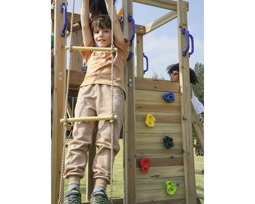 Kind klettert auf Holzspielgerät mit Kletterwand und Strickleiter