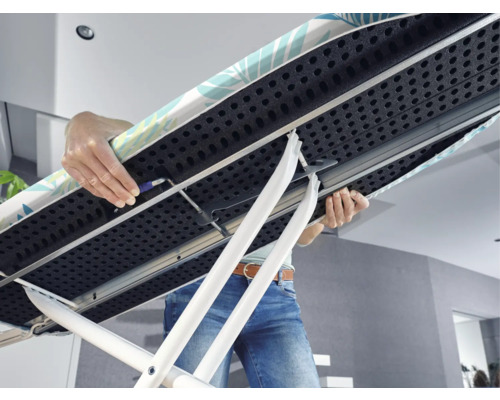 Detailansicht eines Bügelbretts mit Person, die es hält und einstellt.