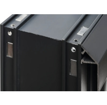 Detailansicht eines schwarzen Aluminiumprofils mit rechteckigen Magneten und Schraubenlöchern