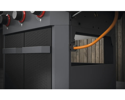 Detailansicht eines Gasgrills mit Schrank und Gasschlauch
