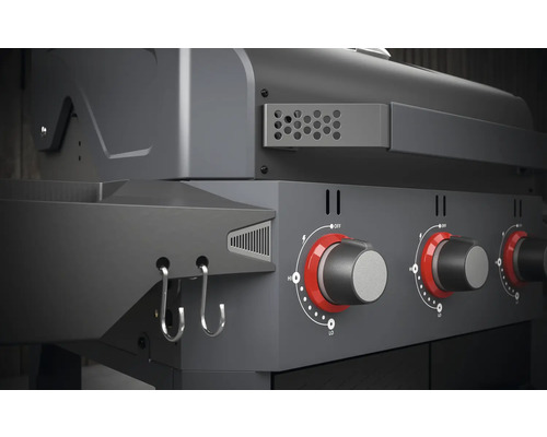 Detailansicht eines Gasgrills mit Drehknöpfen und Haken