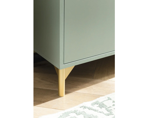 Detailaufnahme eines Schranks mit goldenen Füßen auf einem Holzboden