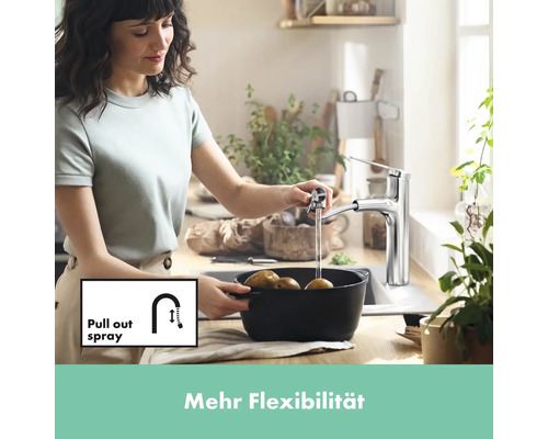 Frau wäscht Kartoffeln mit einer Küchenarmatur mit Ausziehbrause in der Spüle.