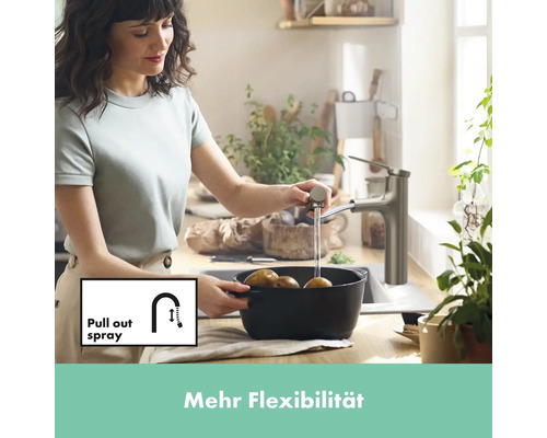 Frau wäscht Kartoffeln mit einer Küchenarmatur mit Ausziehbrause