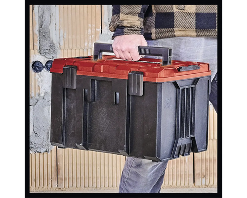 Eine Person trägt einen Werkzeugkoffer aus Kunststoff.