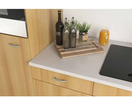 Küchenstillleben mit Ölflaschen, Kräutern und Schneidebrett auf einer Küchenarbeitsplatte