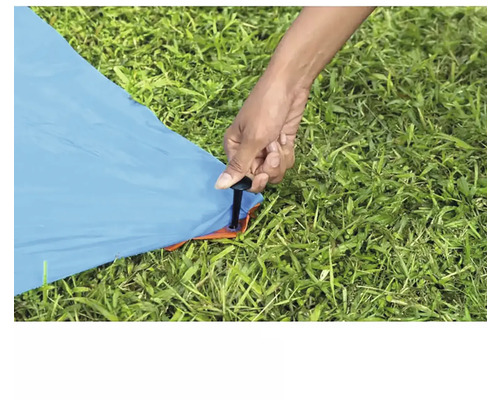 Person befestigt Zelt mit Hering im Boden.