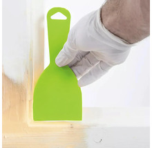 Person mit Handschuh verwendet einen Spachtel