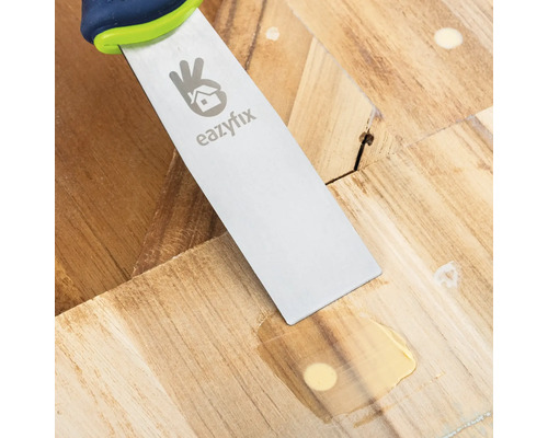 Spachtel beim Ausbessern eines Holzbodens