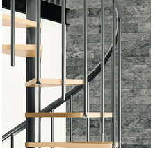 Detailansicht einer Wendeltreppe mit Holzstufen und Metallgeländer vor einer Steinwand