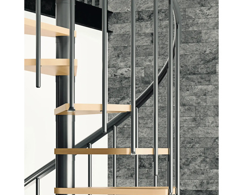 Detailansicht einer Wendeltreppe mit Holzstufen und Metallgeländer vor einer Steinwand