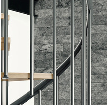 Detailansicht einer Wendeltreppe mit Metallgeländer und Holzstufen vor einer Steinwand.