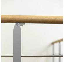 Detailansicht einer Ballettstange mit Holzhandlauf und Metallhalterung.