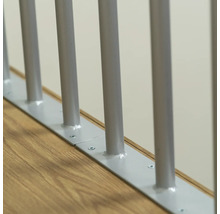 Detailansicht eines Treppengeländers mit Metallstäben und Bodenbefestigung.