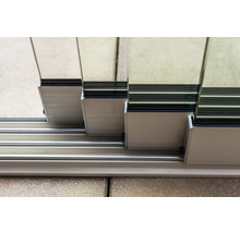 Detailaufnahme einer Glasschiebetür mit Aluminiumrahmen und Führungsschienen.