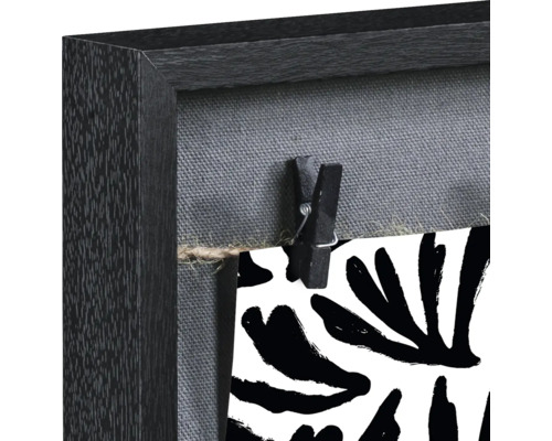 Detailansicht eines Bilderrahmens mit Wäscheklammer und Muster