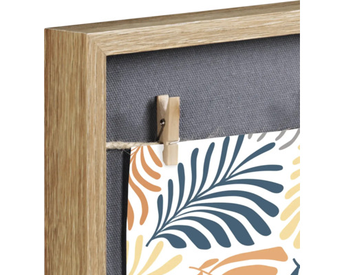 Detailansicht eines Memoboards mit Holzrahmen, Leinwand und kleiner Wäscheklammer