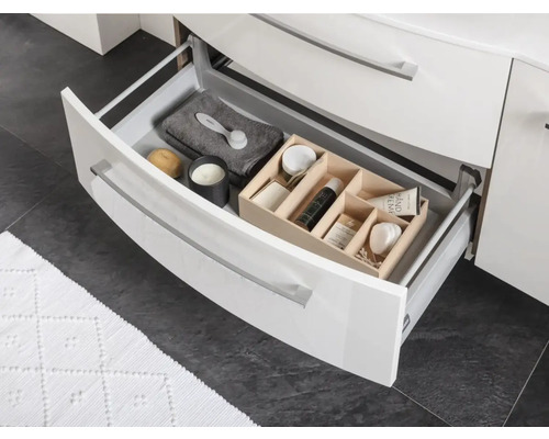 Offene Schublade eines Badezimmerschranks mit verschiedenen Badutensilien.