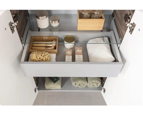 Badezimmerschrank mit offenem Schubfach und Badartikeln