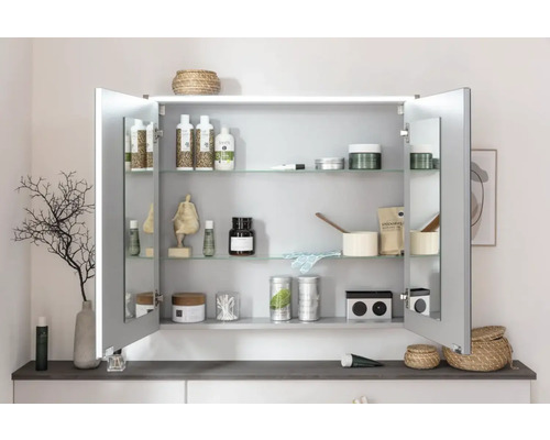 Geöffneter Spiegelschrank mit diversen Badartikeln auf Glasablagen