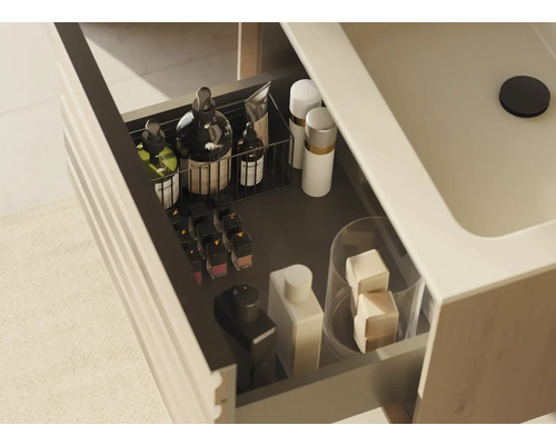 Offene Schublade eines Waschtischunterschranks mit diversen Badartikeln zur Aufbewahrung