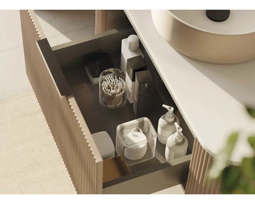 Offene Schublade eines Waschtischunterschranks mit verschiedenen Badutensilien