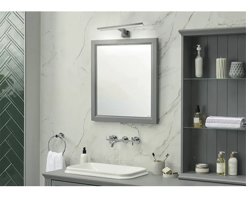 Badezimmer mit Spiegel, Waschbecken, Armatur und Badezimmerschrank