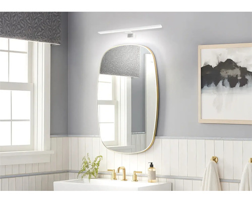 Helles Badezimmer mit Spiegel, Waschbecken und Armaturen