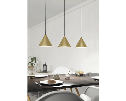 Drei goldfarbene Pendelleuchten über einem Esstisch