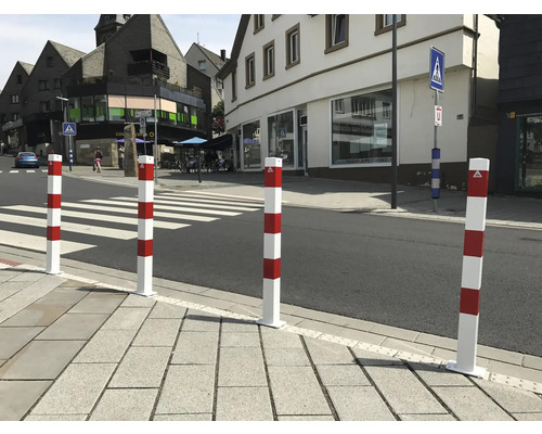 Rot-weiße Sicherheitspoller am Fußgängerüberweg zur Verkehrsregelung.