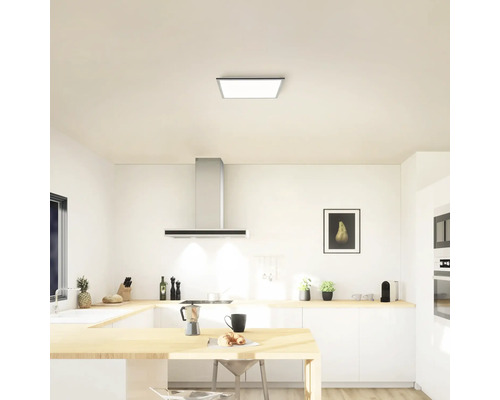 Helle Küche mit Deckenleuchte, Dunstabzugshaube und Küchenmöbeln
